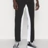 Pegador DEMERE WIDE TRACK PANTS UNISEX - Jogginghose - Black/white